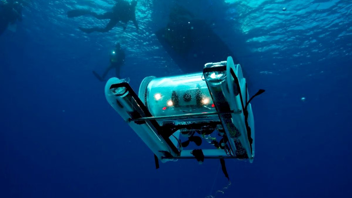 Underwater robot surveying deep sea with divers and research vessel above