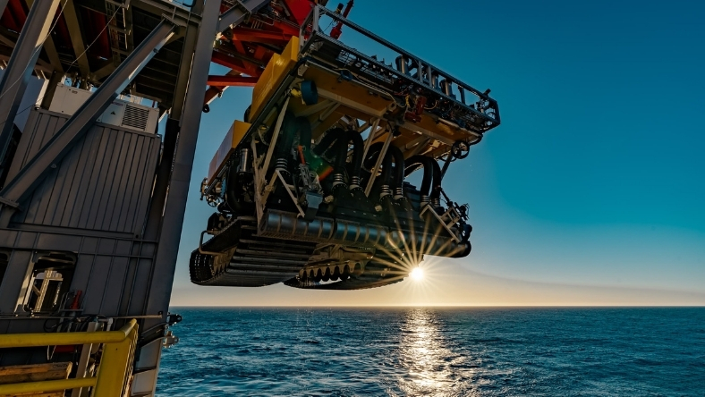 Seabed mining crawler deployed from offshore rig over open water