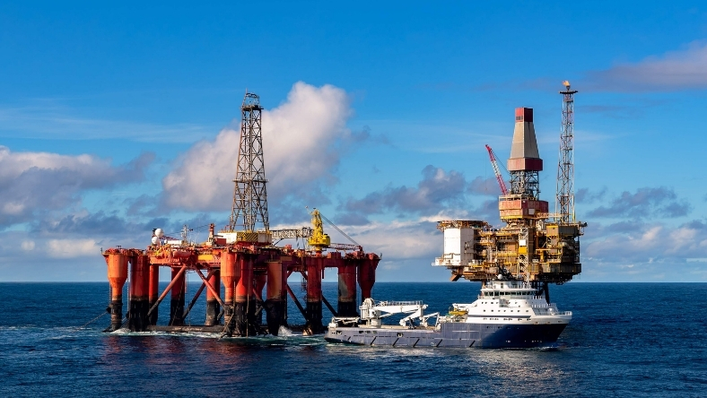 Offshore oil rig with service vessel operating in open oceanc